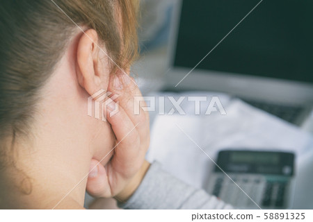 Woman uses a calculator to sum up expenses at home 58891325