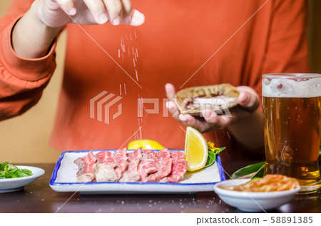 Hands sprinkle salt on sliced grilled Strip Loin Hands sprinkle salt on sliced grilled Strip Loin 58891385