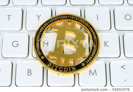 Bitcoin cryptocurrency coin on white keyboard Bitcoin cryptocurrency coin on white keyboard 58892076