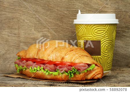 Big croissant with green salad, tomatoes and pork Big croissant with green salad, tomatoes and pork 58892078