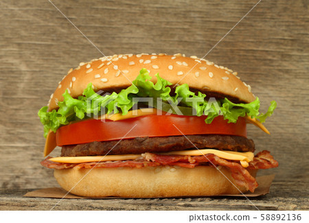 Big hamburger on wooden background Big hamburger on wooden background 58892136