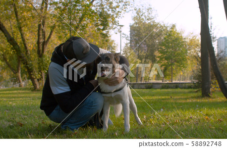 Middle aged man with the dog in the park 58892748