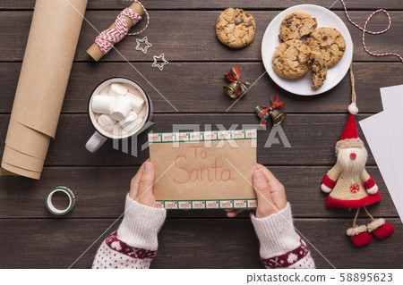 Woman in sweater holding ready letter for Santa Woman in sweater holding ready letter for Santa 58895623