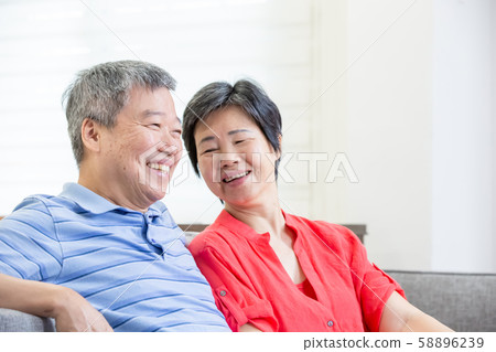 eldely couple sit on sofa 58896239