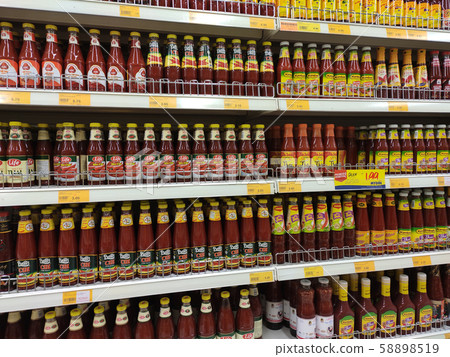 Selective focused variety of cooking sauce in the bottles displayed for sale in the supermarkets. Displayed on racks and separated by the brand to facilitate buyers. Selective focused variety of cooking sauce in the bottles displayed for sale in the supermarkets. Displayed on racks and separated by the brand to facilitate buyers. 58898519