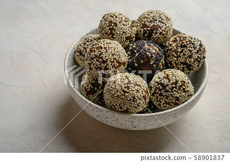Homemade energy balls in a light vase on a white background Homemade energy balls in a light vase on a white background 58901837