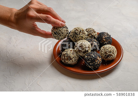 Woman's hand holds an energy ball over a plate Woman's hand holds an energy ball over a plate 58901838