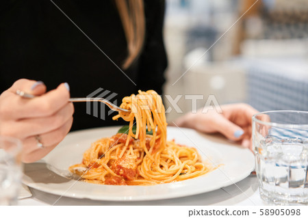 Close-up spaghetti Bolognese wind it around a fork. Parmesan cheese. Young woman eats Italian pasta 58905098