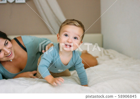 Charming happy little baby boy having fun with mom Charming happy little baby boy having fun with mom 58906845