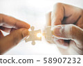 Closeup hand of man connecting jigsaw puzzle with 58907232