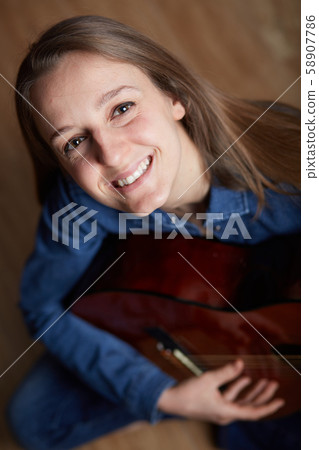 woman play guitar at home 58907786