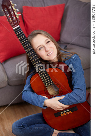 woman play guitar at home 58907788