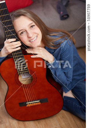 woman play guitar at home 58907789