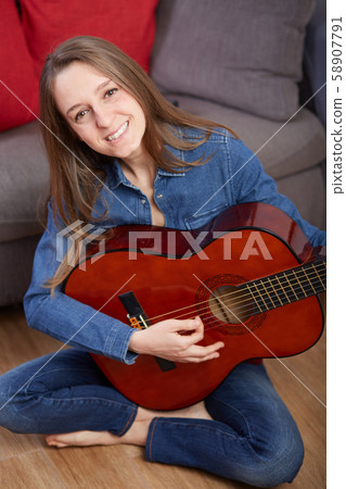 woman play guitar at home woman play guitar at home 58907791