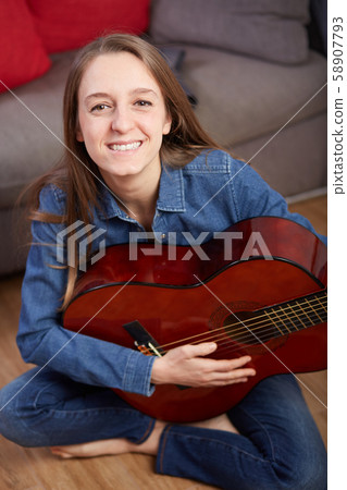 woman play guitar at home 58907793