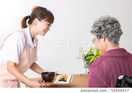 Caregivers and helpers carrying meals with elderly women Caregivers and helpers carrying meals with elderly women 58908457