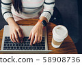 Coffee cup and Laptop in girl's hands.Woman hands 58908736