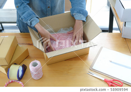 Online sellers are packing products into boxes for shipping to customers. 58909594