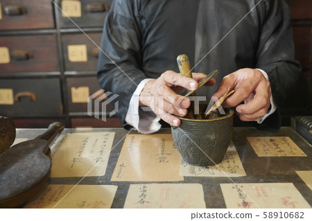 Apothecary worker grinding up shiitake Apothecary worker grinding up shiitake 58910682