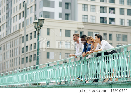 Happy coworkers standing on bridge Happy coworkers standing on bridge 58910751