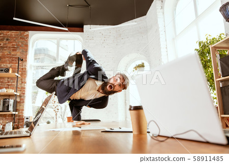 Businessman having fun dancing break dance in the office at work Businessman having fun dancing break dance in the office at work 58911485