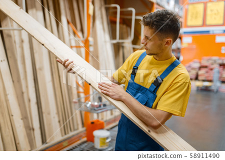 Constructor choosing wooden boards, hardware store 58911490