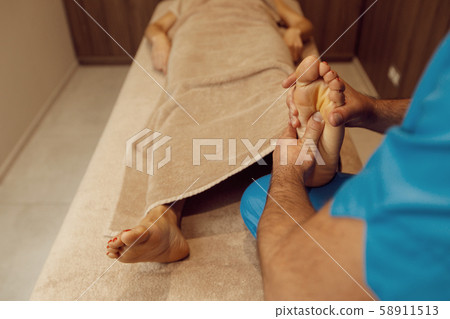 Male masseur pampering foot to woman, massage Male masseur pampering foot to woman, massage 58911513