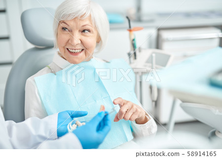 Senior lady asking questions about dental dentures 58914165