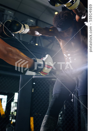 Boxer delivering a stomach punch 58914989