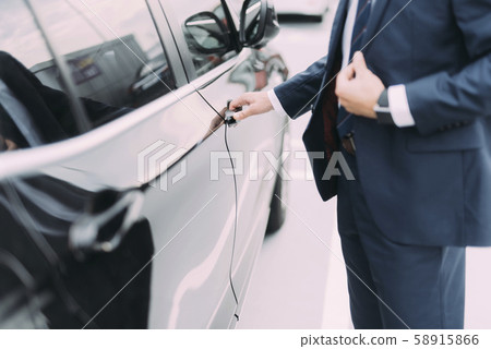 Man in suit getting into car stock photo Man in suit getting into car stock photo 58915866
