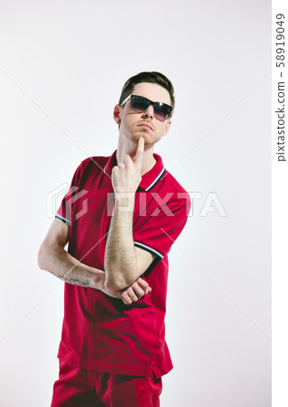 Handsome man wearing styled sunglasses and marsala clothes, shirt, jeans. on White. Direct trendy Handsome man wearing styled sunglasses and marsala clothes, shirt, jeans. on White. Direct trendy 58919049
