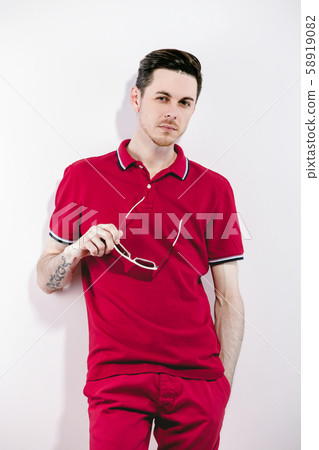 Handsome man wearing styled sunglasses and marsala clothes, shirt, jeans. on White. Direct trendy Handsome man wearing styled sunglasses and marsala clothes, shirt, jeans. on White. Direct trendy 58919082