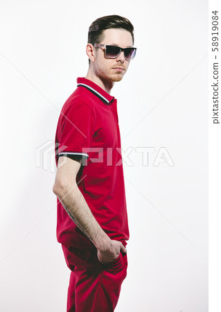 Handsome man wearing styled sunglasses and marsala clothes, shirt, jeans. on White. Direct trendy 58919084