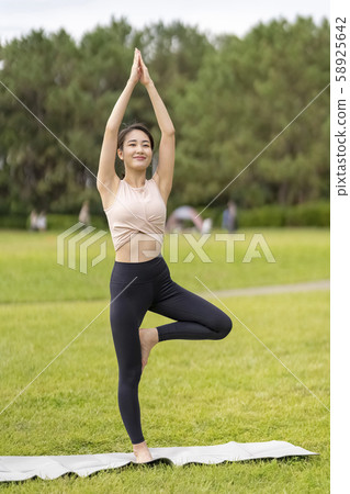瑜伽在草地上放鬆的感覺(樹形)一隻腳站立以形成平衡感,並使腿部和臀部塑形 瑜伽在草地上放鬆的感覺(樹形)一隻腳站立以形成平衡感,並使腿部和臀部塑形 58925642