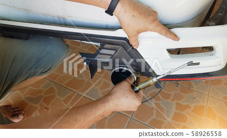 Middle-aged men take out car decoration set, due to rupture  accident. 58926558