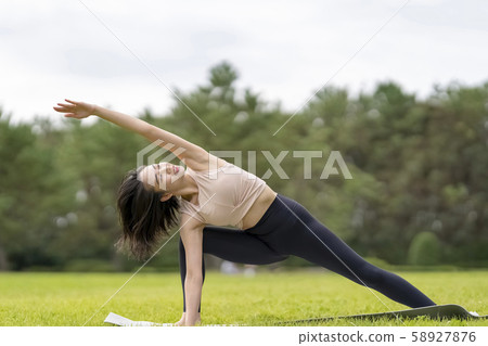 Yoga Relaxing feeling in grass park (pose to stretch the side of body) Back pain Relieve illness during menstruation Eliminate constipation Sciatica Yoga Relaxing feeling in grass park (pose to stretch the side of body) Back pain Relieve illness during menstruation Eliminate constipation Sciatica 58927876