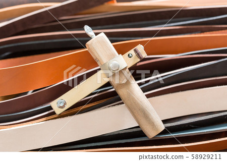 The strap cutter close up on leather pieces. The strap cutter close up on leather pieces. 58929211