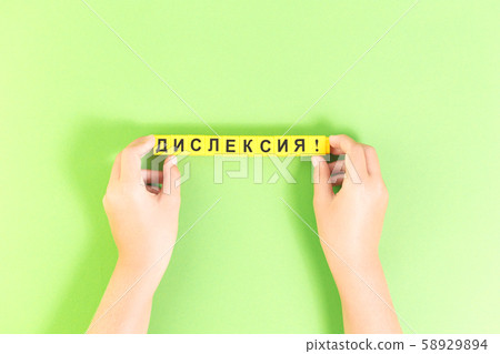 Hands with Dyslexia word in Russian on green 58929894