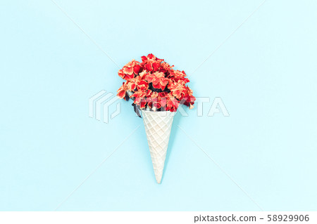 Orange autumn flowers in waffle cone on light blue Orange autumn flowers in waffle cone on light blue 58929906