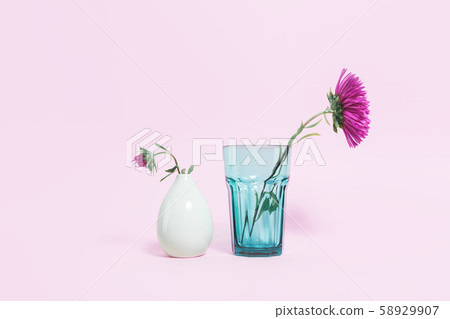 Two Pink flowers in green glass vases on pink 58929907