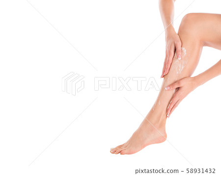 Female hands applying cream on the skin of her leg, close up Female hands applying cream on the skin of her leg, close up 58931432