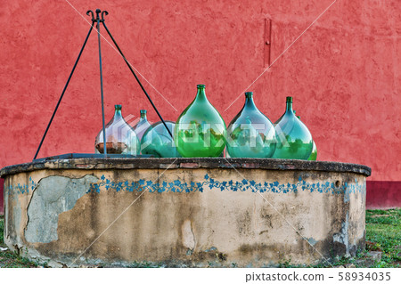 Water well with empty old wine jars. Tuscany, 58934035