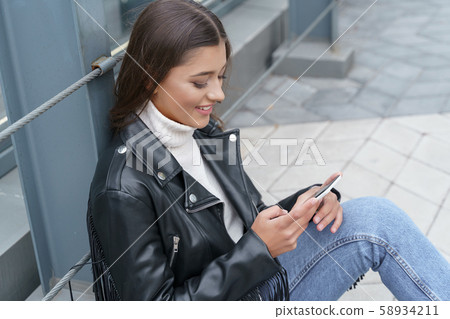 Cheerful woman receiving messages from her friends Cheerful woman receiving messages from her friends 58934211
