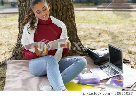 Beautiful cheerful student working on her homework 58935027