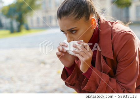 Sad woman being sick walking in the park 58935118