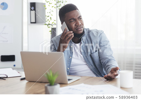 Upset african american employee getting bad news on phone 58936403