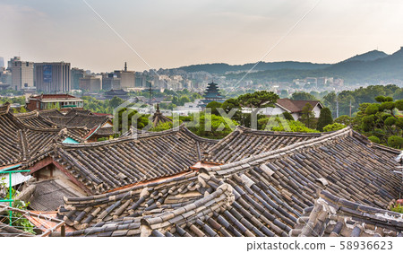 Hanok roof and Gyeongbokgung Palace and city view in the distance 58936623