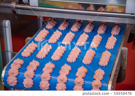 Cakes on automatic conveyor belt , process of 58938476