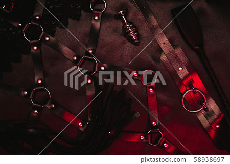 Set for BDSM sex in a sex shop. Metal anal plug, leather whip Flogger Set for BDSM sex in a sex shop. Metal anal plug, leather whip Flogger 58938697