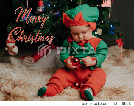 small baby boy in elf costume with balls at the tree small baby boy in elf costume with balls at the tree 58938698